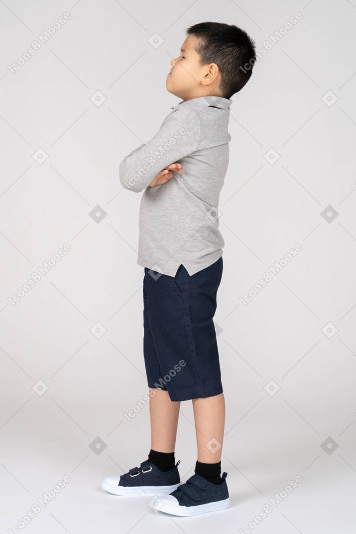 Unhappy boy with crossed arms in profile