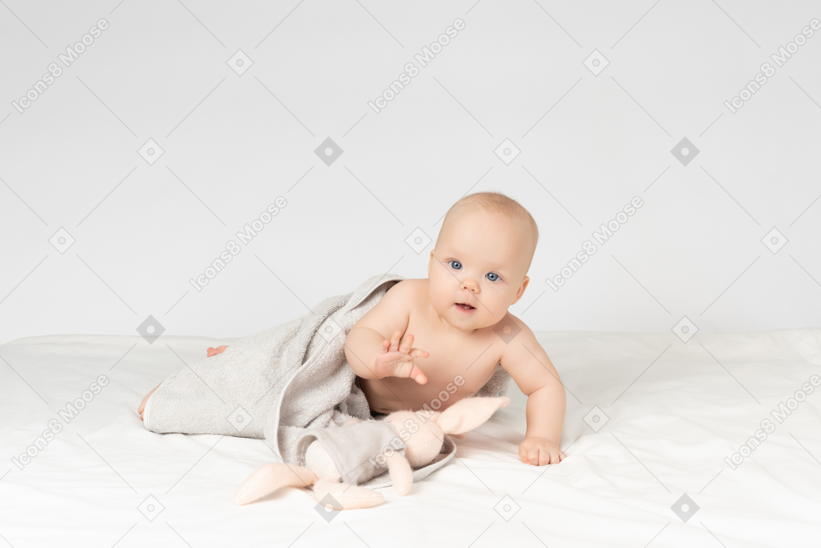 Baby girl covered in towel and holding a toy