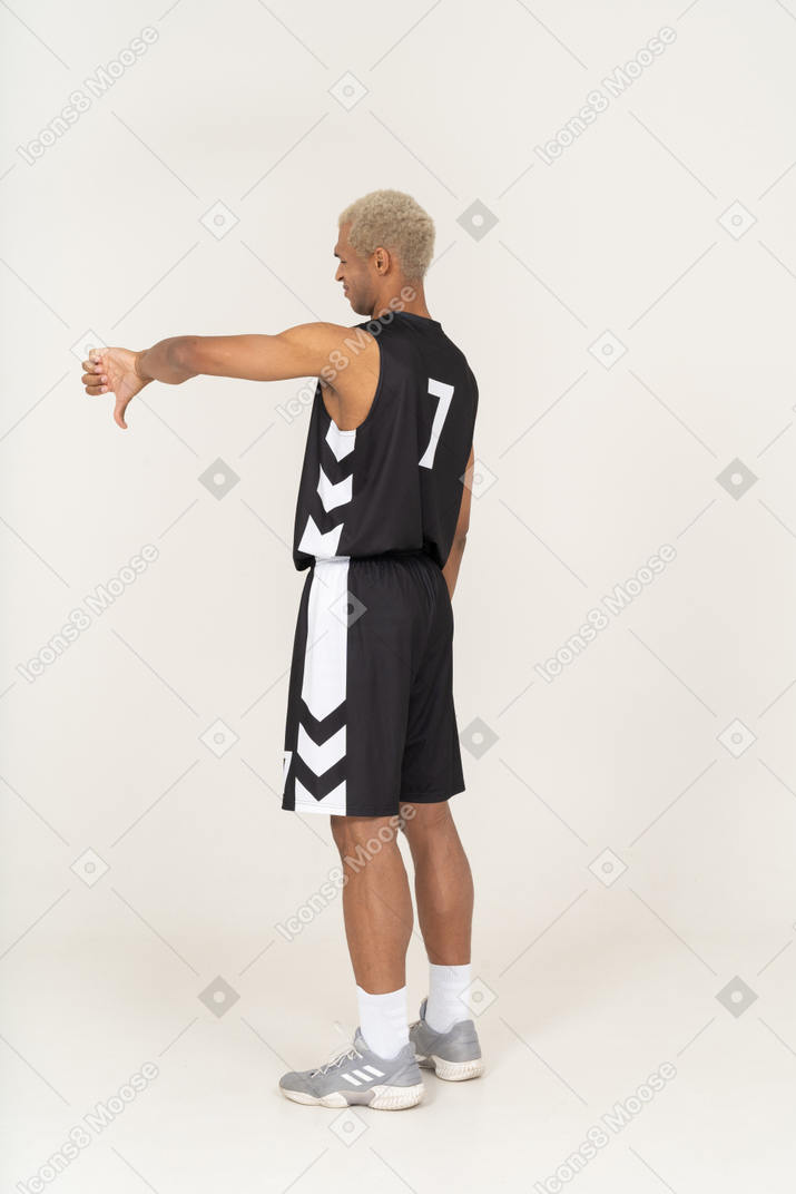 Three-quarter back view of a young male basketball player showing thumb down