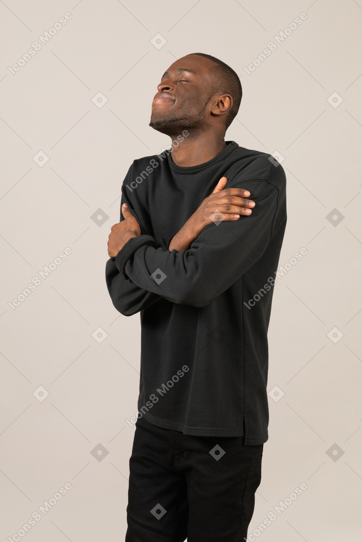 Relaxed black man embracing himself
