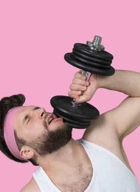 A man lifting a dumbbell on a pink background