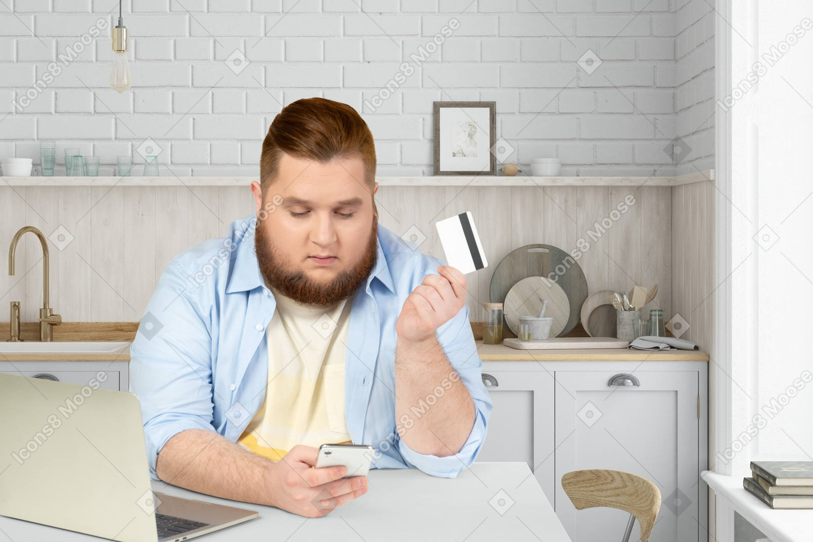 A man sitting at a table with a credit card and a laptop