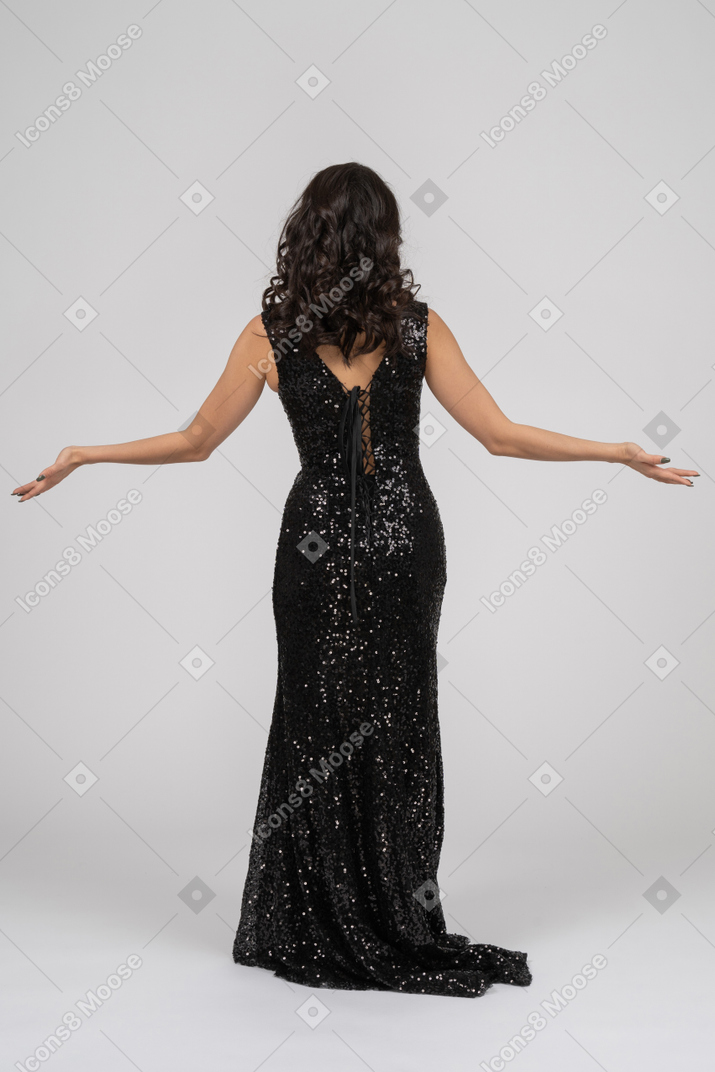 Mulher de vestido preto, esticando as mãos para os lados