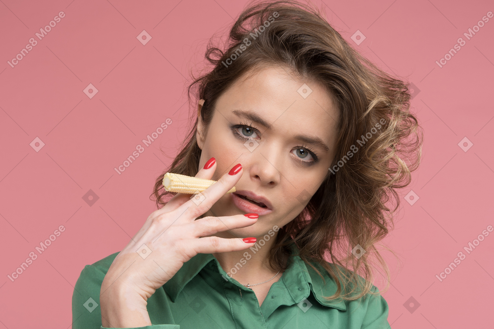 Woman holding baby corn as a cigar