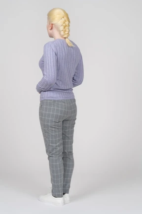 Three-quarter back view of a standing young woman