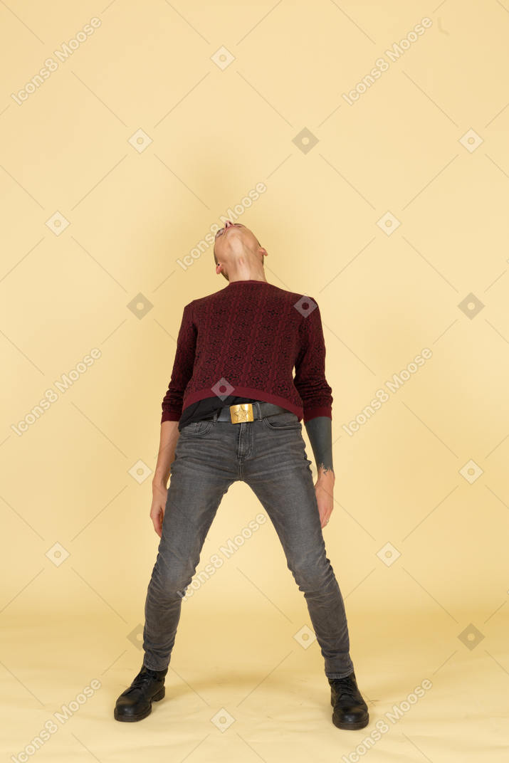 Вид сзади молодого человека в красном пуловере, откинувшись назад