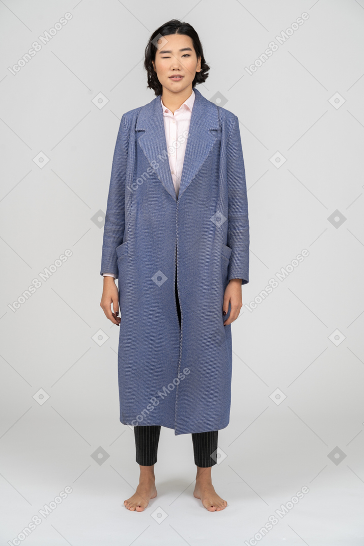 青いコートを着たウィンクする女性