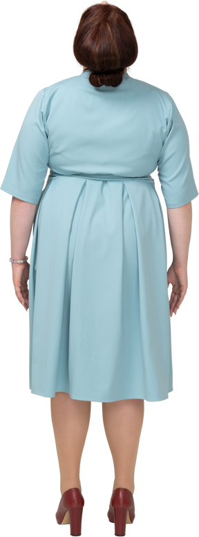 一个穿着蓝色连衣裙的女人仰望的后视图