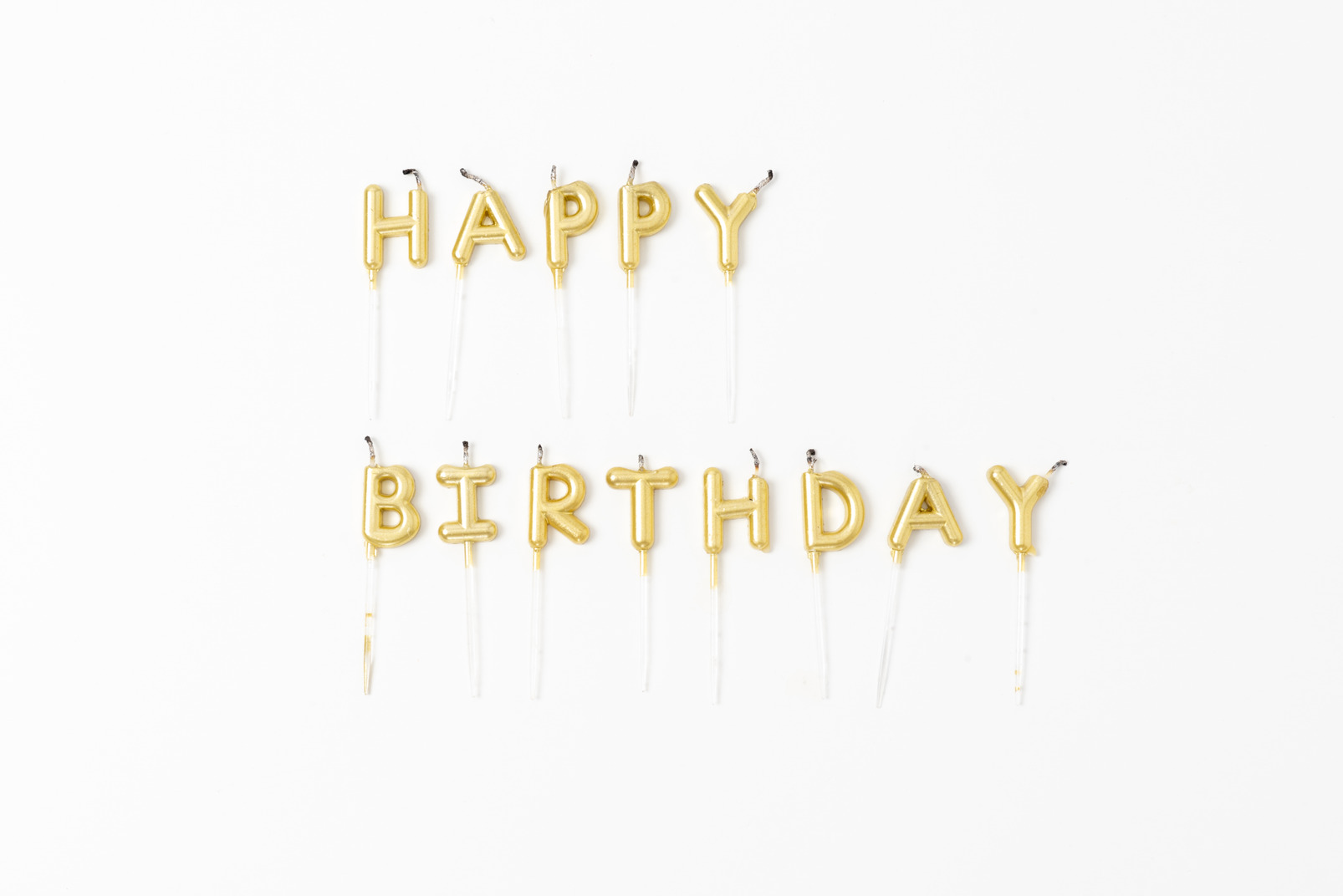 Golden letter candles on a white background