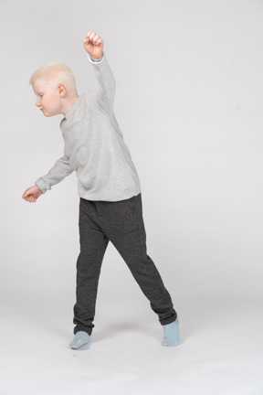 Vista frontal de un niño con los puños en alto
