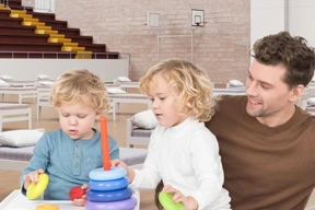 A man and two children playing with toys