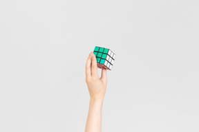 Mano femenina sosteniendo kubik rubik