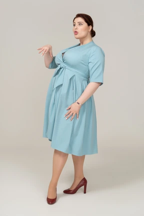 Side view of a woman in blue dress making faces