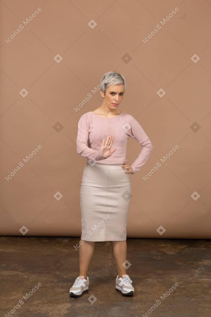 一个穿着休闲服的女人的前视图，显示停止手势