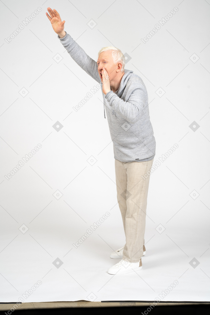 Three-quarter view man standing with raised arm and yelling