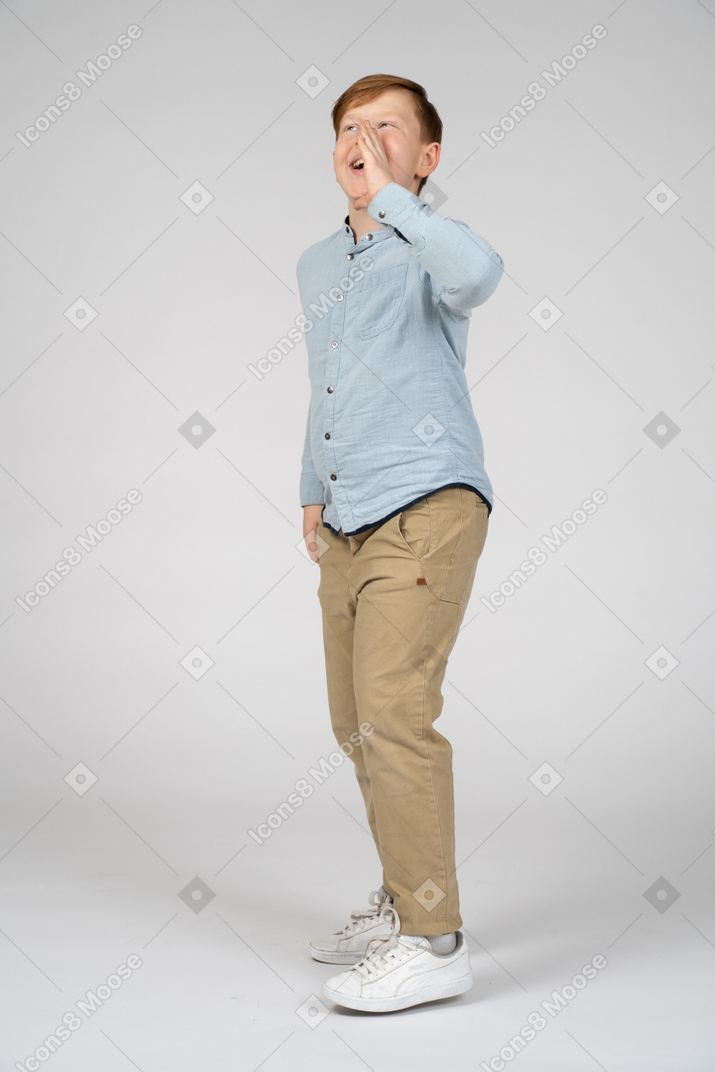 Side view of a boy calling someone