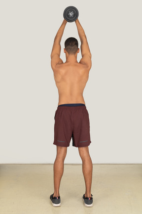 Back view of muscular man holding dumbbell