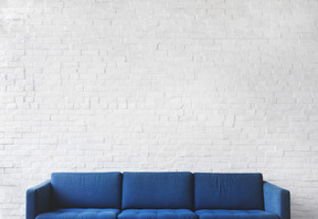 Blaues sofa auf weißer wand