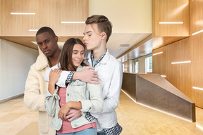 Young embracing couple and pensive lonely man