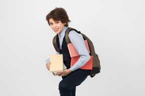 Schoolboy carrying a bunch of books