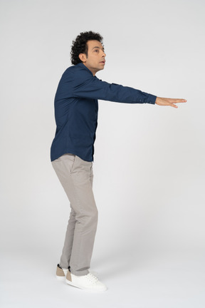 一个穿着休闲服的男人张开双臂站立的侧视图