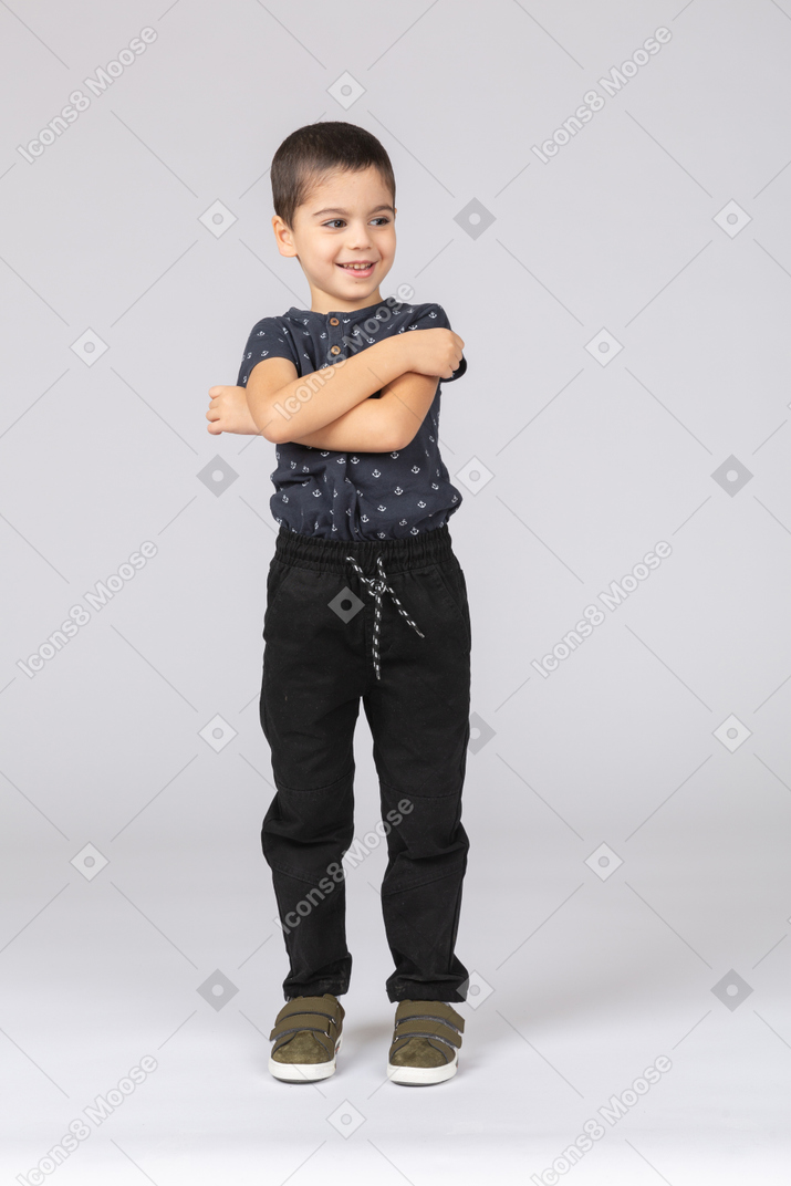 一个可爱的男孩交叉双臂摆姿势的前视图