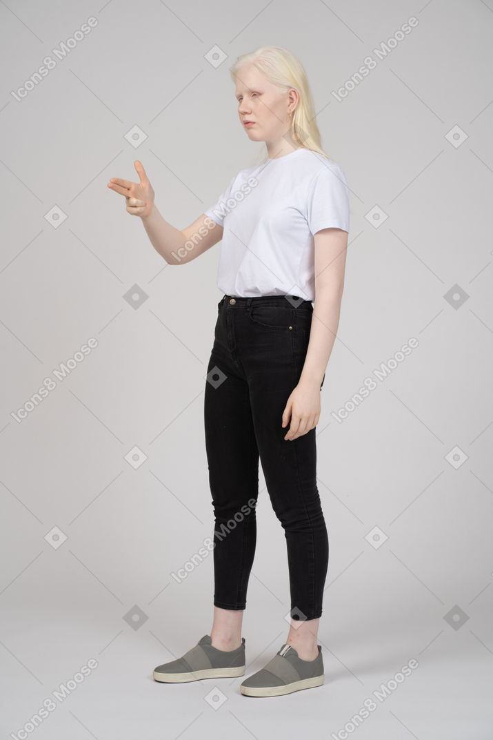 Mujer joven haciendo una pistola de dedo