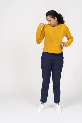 Front view of a girl in casual clothes checking if her shirt is clean