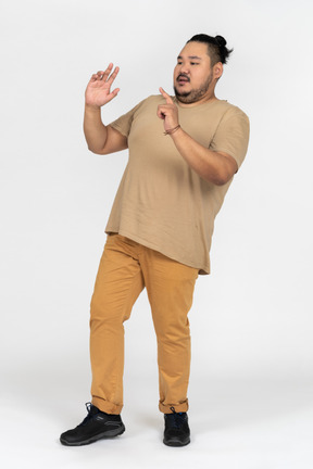 Homem asiático barbudo gordo, gesticulando com as duas mãos