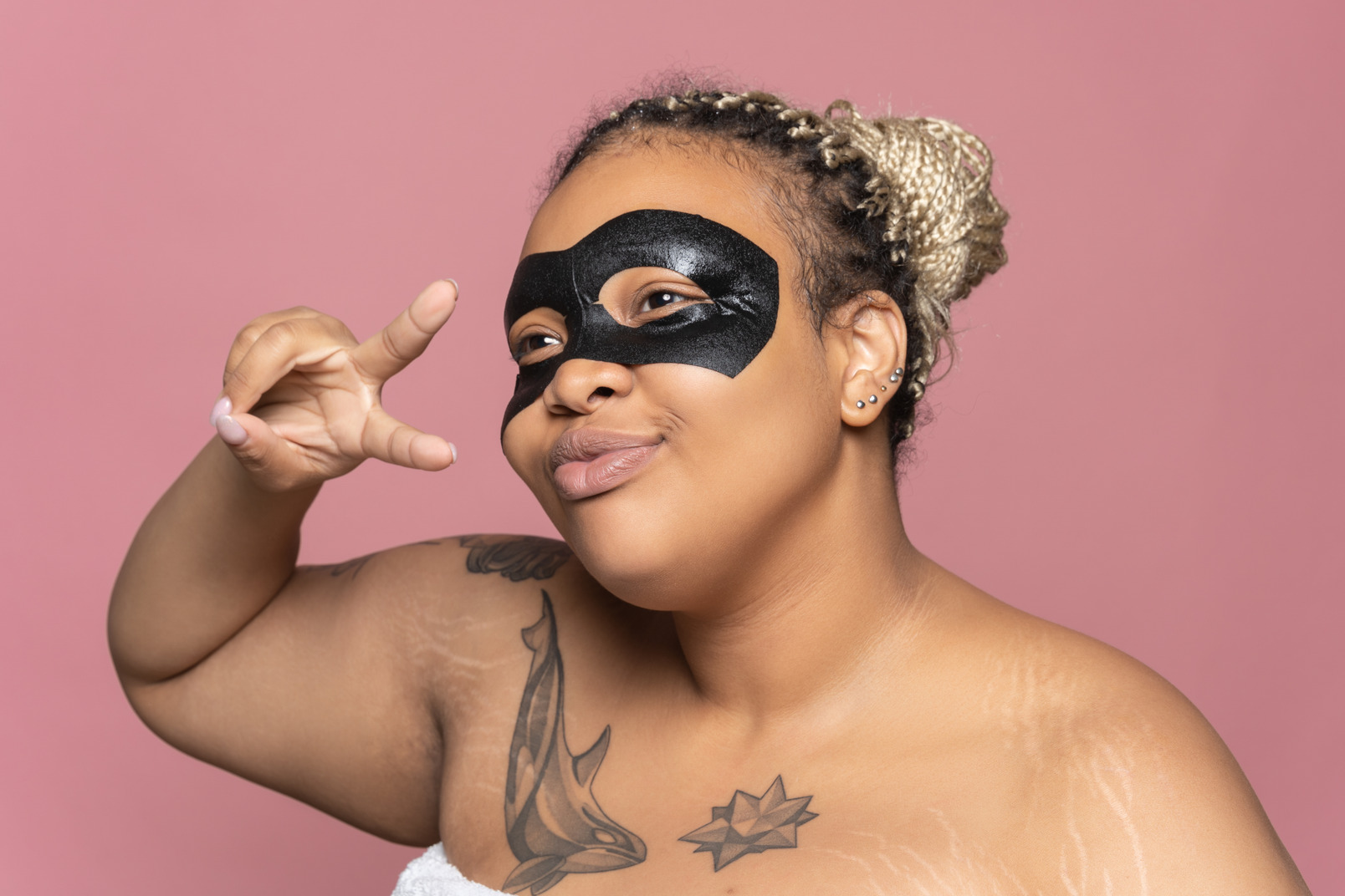 Plus size woman with black eye mask looking at mirror