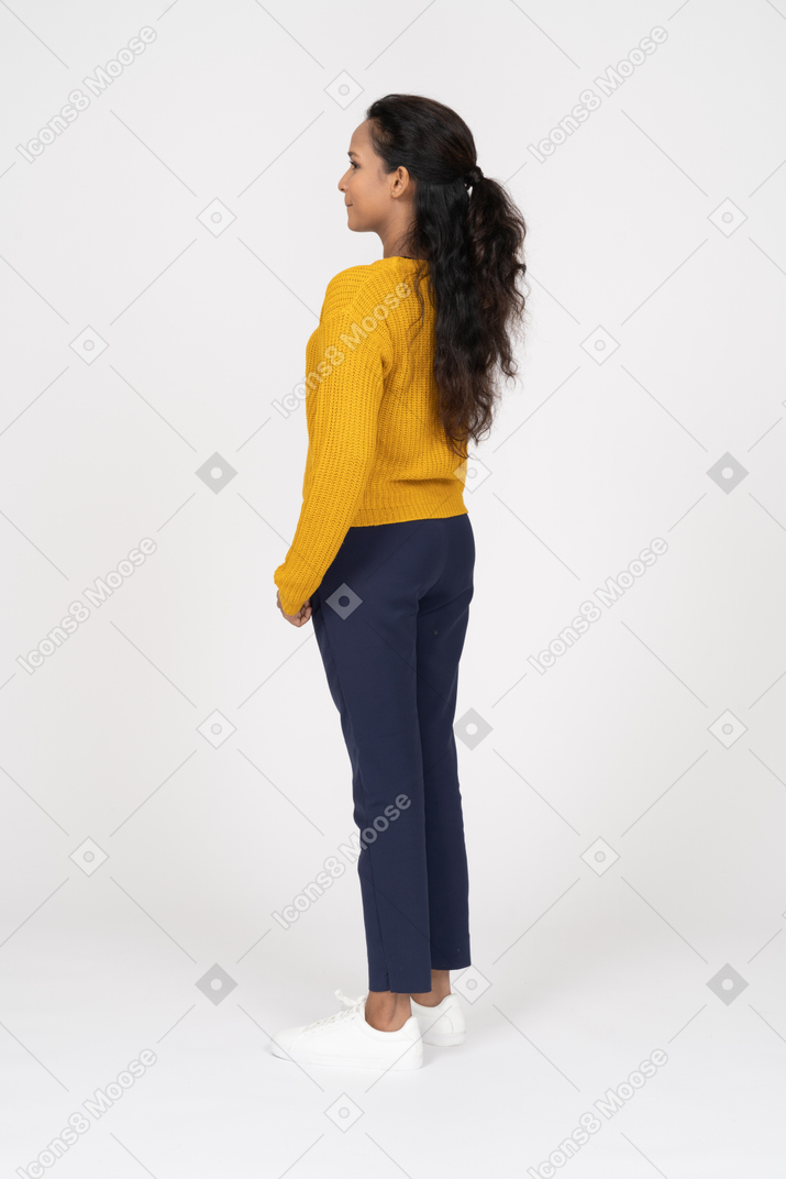 Side view of a girl in casual clothes standing with hand in pocket