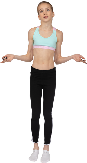 Vista frontal de uma adolescente em roupas esportivas levantando as mãos e raciocinando