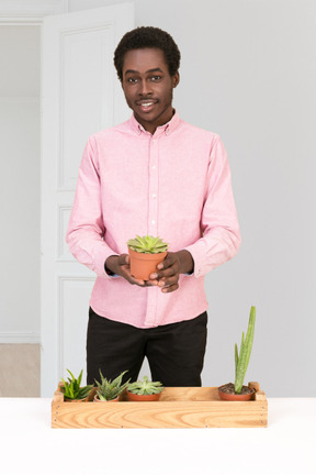 A man holding a potted plant in his hands