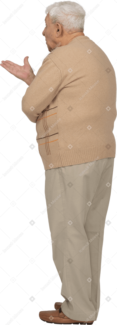 Side view of an old man in casual clothes explaining something