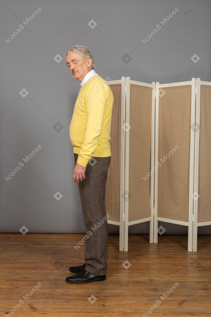 Side view of a sleepy old man standing by the screen