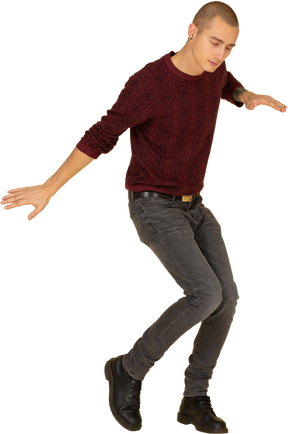 Трехчетвертный вид танцующего молодого человека в красном пуловере