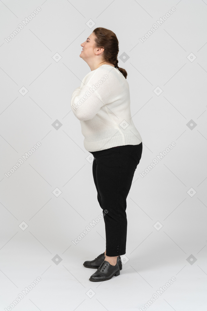 Vista laterale di una donna grassoccia felice in abiti casual