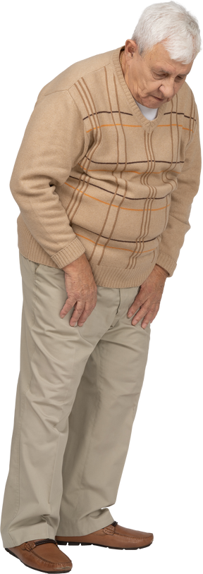 Front view on an old man in casual clothes looking down