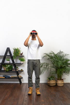 Good looking young man holding binoculars