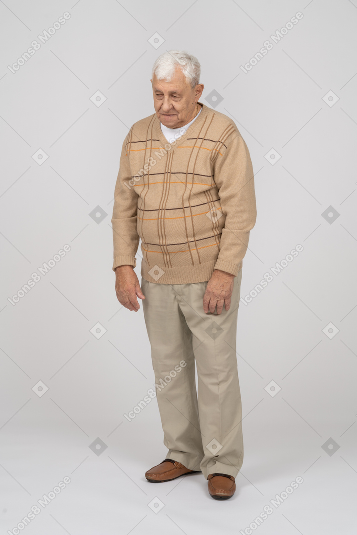 じっと立っているカジュアルな服装の老人の正面図