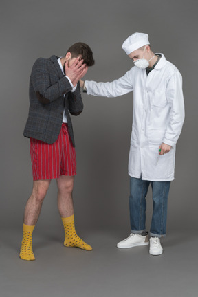 Doctor y joven llorando a alguien
