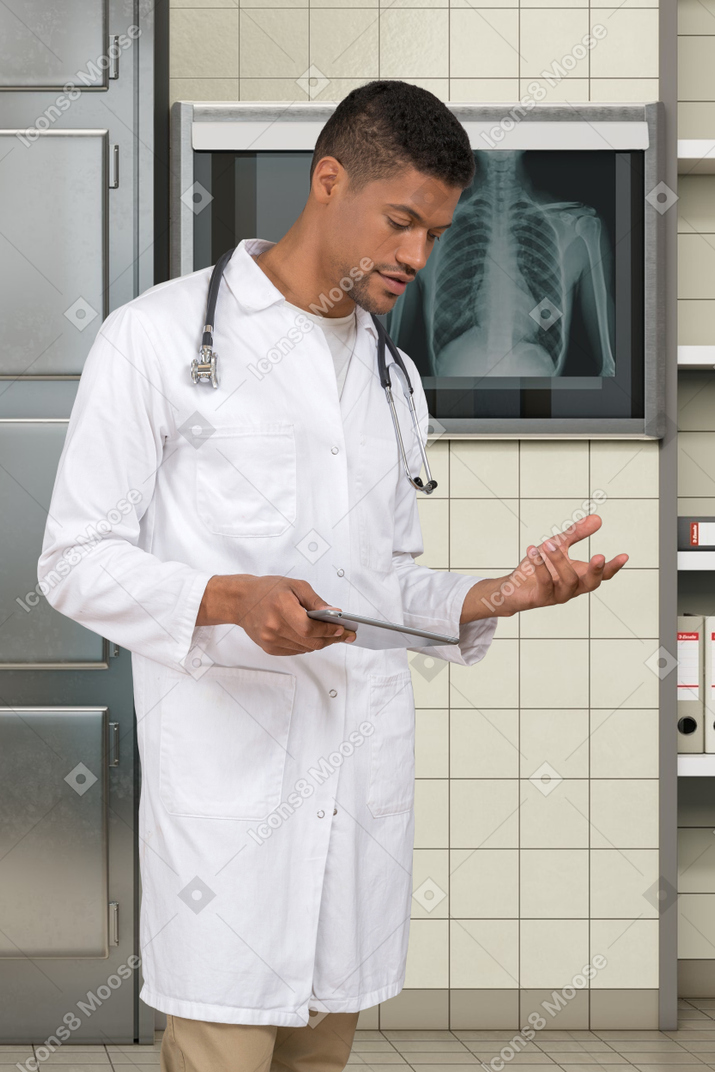 A man in a white lab coat holding a clipboard