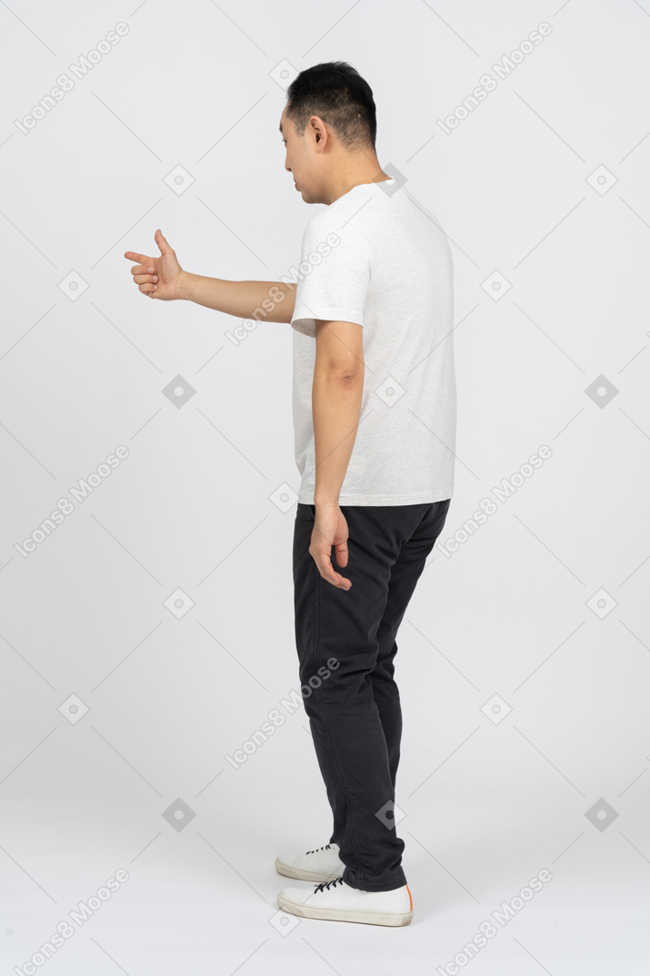 Side view of a man in casual clothes pointing at something with finger