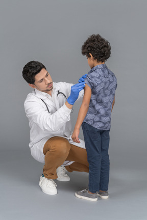 Médico e menino após vacinação