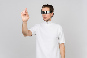Hombre con gafas futuristas trabajando con interfaz virtual.