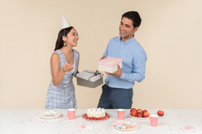 Joven asiática dando regalos a un chico caucásico