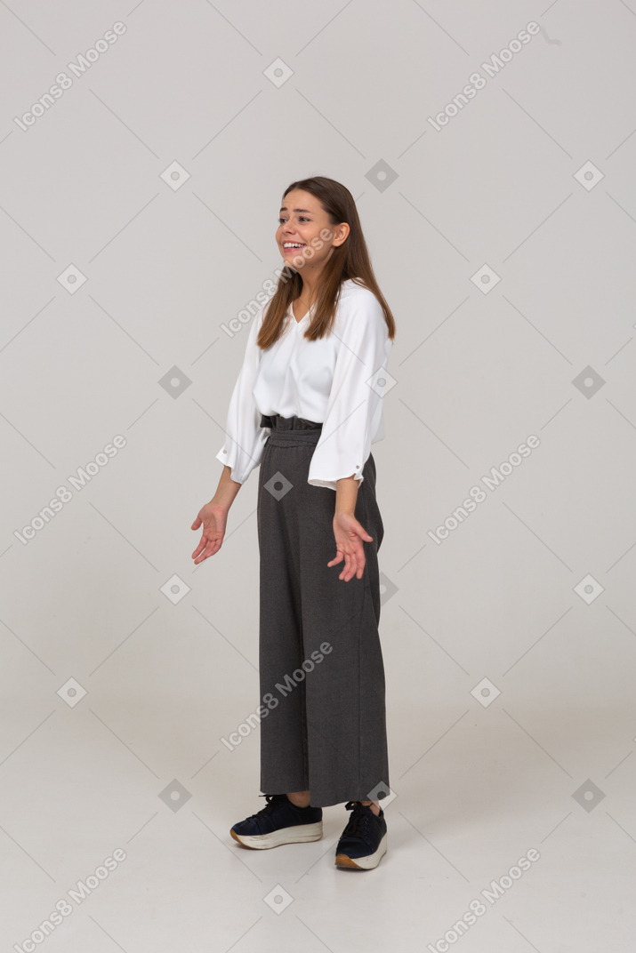 Dreiviertelansicht einer lachenden jungen dame in bürokleidung mit ausgebreiteten armen