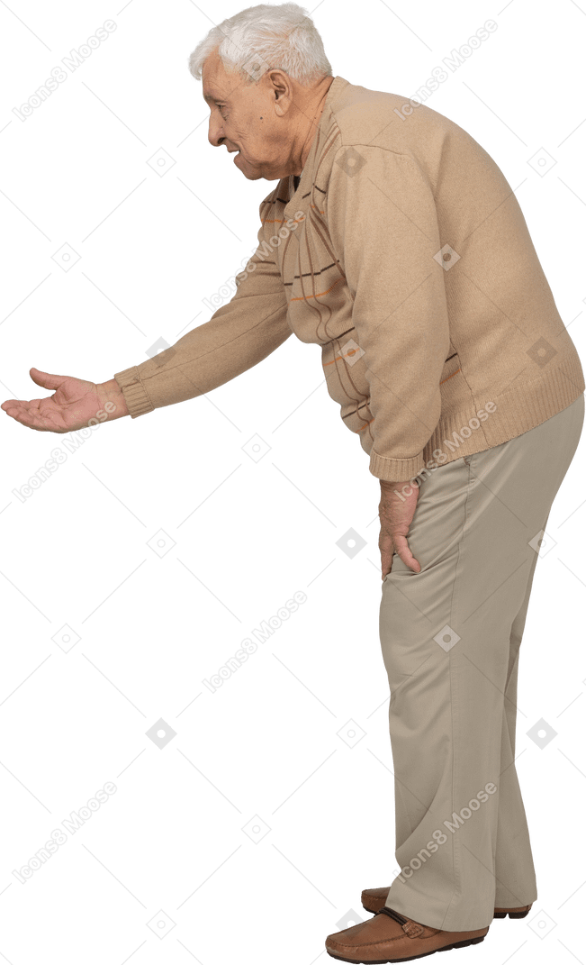 Vista lateral de un anciano con ropa informal de pie con el brazo extendido