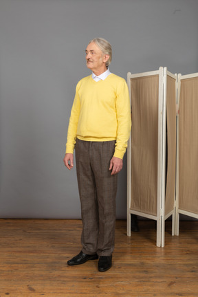 Front view of an old man standing still and looking aside