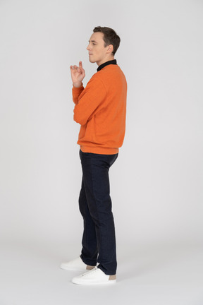 Young man in orange sweatshirt standing